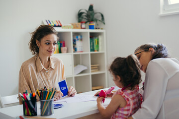 Learning letters together mother with daughter and teacher