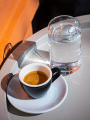 Espresso with a glass of water on the summer terrace