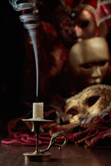 Still life with an extinguished candle and carnival masks.
