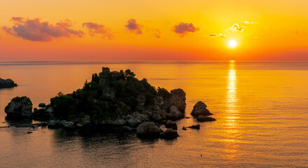 amazing view to a sunrise or sunset above beautiful isle in sea with nice coasline and clouds on the background of the evening sea landscape