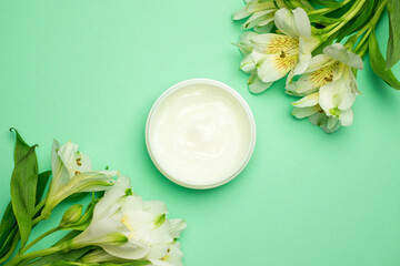 Natural organic cream moisturizer and plant leaves on green background. Nature skincare cosmetic s concept.