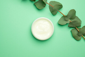 Spa natural organic cream moisturizer and plant leaves on green background. Nature skincare cosmetic s concept.