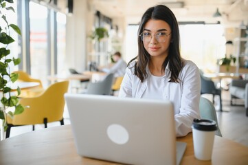 Smiling girl student study online with skype teacher, happy young woman learn language listen...