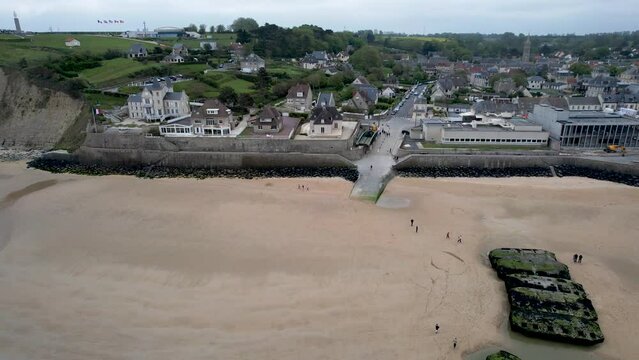 Aerial panning view of Arromanches les Bain, Normandy France with ww2 bunkers on beach