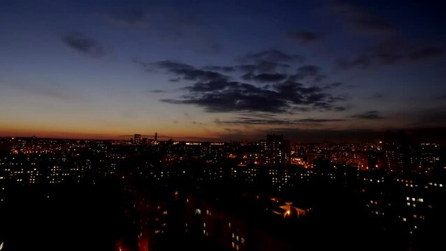 Sunset Hyperlapse. The sun slowly descends behind the buildings of the city and goes beyond the horizon. Clouds float beautifully and smoothly across the sky.  Minsk, Belarus. 