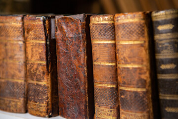 Very old books sitting on the shelves in the library. Books as a symbol of knowledge.