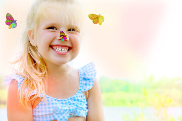 Portrait of laughing toddler pretty girl with butterfly. Fun time on the beach.  Happy childhood...
