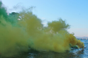 Colored smoke on water. Concept of celebration, creativity. Copy space.