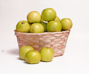  Yellow natural apples in a straw basket on a white isolated background