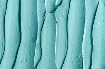 Blue, green bentonite facial clay (alginate modeling mask, face cream, body wrap) texture close up, selective focus. Abstract background with brush strokes.