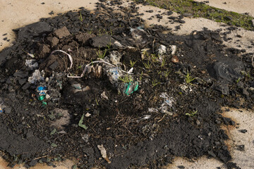 Concept vandalism remains of a burnt garbage can melted plastic and garbage residues poison dioxin releasing