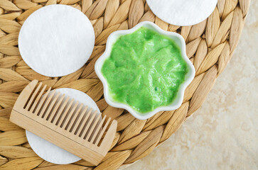 Homemade matcha green tea (kelp, algae, spirulina) hair, face or eye mask in a small white bowl and...