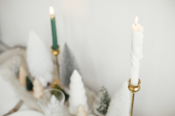Stylish Christmas table setting. Christmas candle close up, vintage cutlery, wineglass, modern...
