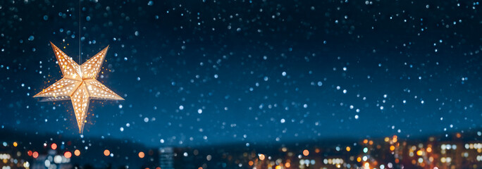 Christmas star-shaped lamp against the backdrop of the night snowy city. Cozy fairytale atmosphere...