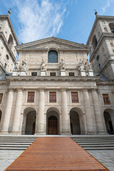 Statues of kings on the granite facade of one of the entrances to the El Escorial Monastery in Madrid with a wooden ramp to save the steps