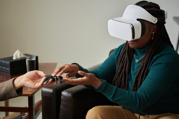 African American girl trying to overcome her phobia of spiders with virtual therapy while visiting...