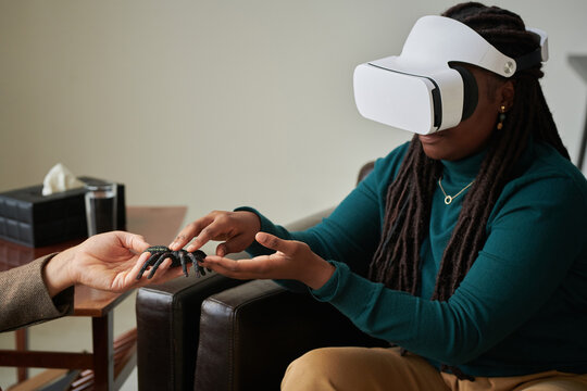 African American girl trying to overcome her phobia of spiders with virtual therapy while visiting psychologist at office