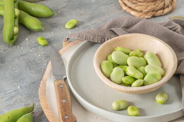 Fresh and raw green broad beans on kitchen table.