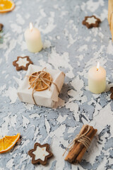 Christmas still life on the windowsill. Concrete background, gifts, candles and garlands