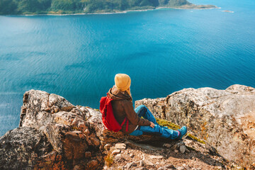 Female traveler with backpack enjoying aerial fjord view travel hiking outdoor in Norway active healthy lifestyle vacations trip eco tourism