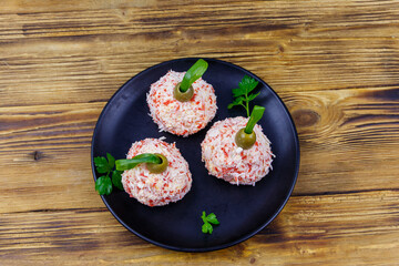 Appetizer of crab-cheese balls made in a shape of Christmas baubles on wooden table. Top view