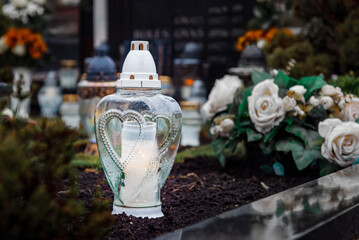 All Saints' Day and burning candles and flowers on the graves.Candles on graves symbolize the...