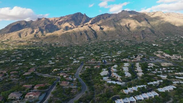 Aerial Drone Shot of Neighborhood of Catalina Foothills in Tucson Arizona on Sunny Day, Mountains In Background and Houses Below
