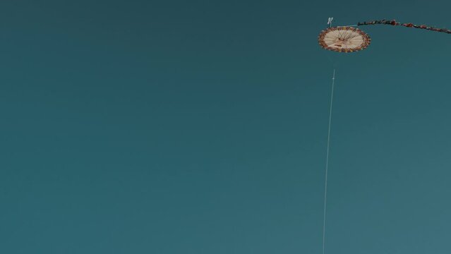 Giant Kite Flying Against Blue Sky In Honor Of The Dead During Dia De Los Muertos In Sumpango, Guatemala - low angle shot
