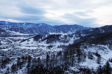 Mountains in snow and village in siberia