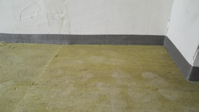 Damper tape for underfloor heating, how to use for underfloor heating screed. Sticking damper tape for pouring the floor. Gluing tape for further pouring the floor.