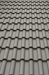 Mehrere Reihen von dunkelgrauen Dachziegeln.