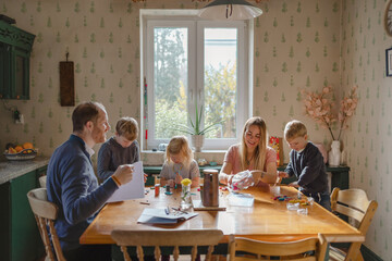 Happy young family at dining table at home together 
