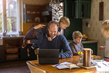Fototapeta premium Dad using tablet at home with kids 
