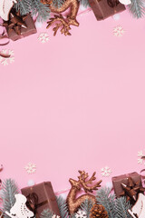 Pine trees branches with Christmas New Year decoration top view, flat lay on pink background with copy space