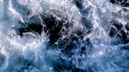 Abstract blue sea water with white foam for background, nature background concept, sea foam texture, with space for text with blanks.