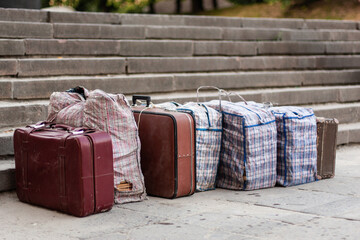 many suitcases and bags are lined up on the street.