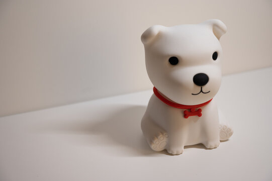 white toy dog sitting in front of white background