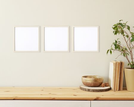 Living room interior and three square frames mockups on the wall for art, design presentation, wooden shelf, books, plant.