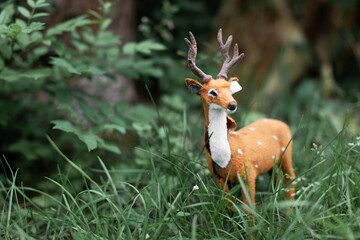 a beautiful little figure of a spotted deer in the grass.