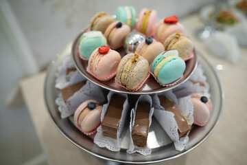 various delicious macaron cookies on a round stand tray.