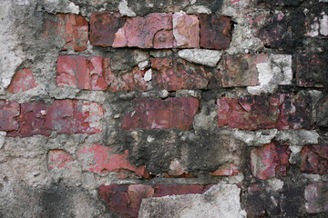 old broken brick wall with cracked plaster vintage texture.