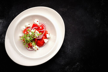 Salad with tomatoes and cheese on a plate