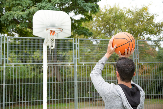 Man throwing a three-pointer on a basketball court
