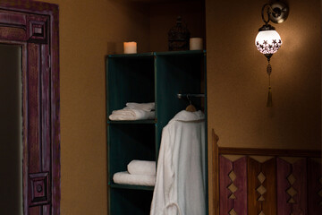 White bathrobes hanging in wardrobe in spa salon
