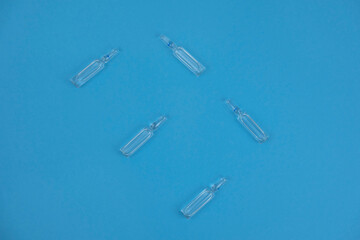 ampoules for injection on a blue background. background for medicine and cosmetology