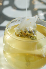 green tea and tea bag on table, close up.
