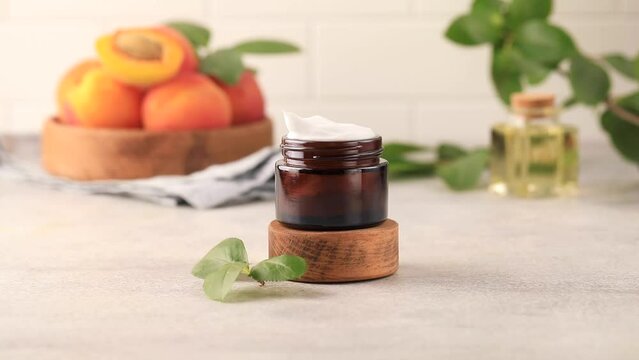 A woman's hand takes a moisturizing cream with apricot seed extract. 