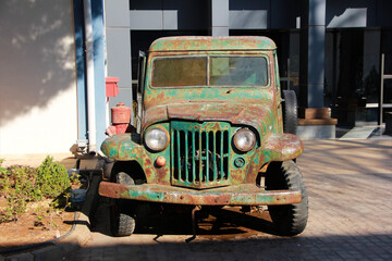 An old green truck with a body and rust spots