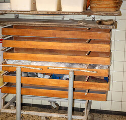 In einem Regal an der Wand in einer Backstube lagern die Bretter für die Brote.