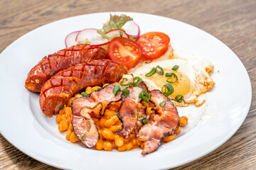 breakfast plate with sausage, bacon, egg and beans